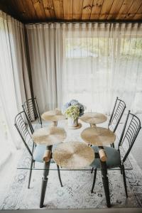 una mesa con cuatro sillas y un jarrón de flores en Tatahi Lodge Beach Resort en Hahei