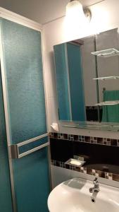 ein Bad mit einem Waschbecken, einem Spiegel und einer Dusche in der Unterkunft Gardella House, Casa - Hotel in Ica