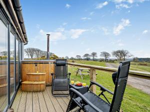 a deck with a table and chairs on a house at 1 Bed in Dalry 91417 in Dalry