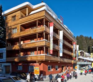 a building with people walking in front of it at Arosa Vetter Hotel in Arosa