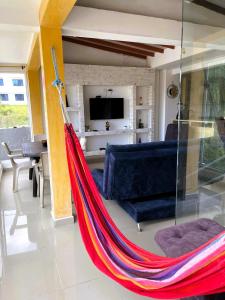 a hammock in a living room with a couch and a tv at Tu Refugio Perfecto en el Eje Cafetero, Tranquilidad y Comodidad en Santa Rosa de Cabal, Estrategicamente Cerca de Pereira, Armenia y Manizales in Santa Rosa de Cabal