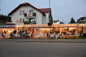 a restaurant with tables and chairs in front of a building at Bursztynek in Władysławowo