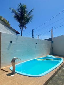 einen Pool mit einem Wasserhahn neben einer Wand in der Unterkunft Casa Arembepe 2 in Camaçari