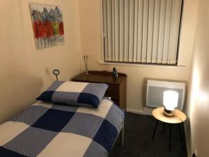 1 dormitorio con 1 cama y 1 mesa con lámpara en Lavender Cottage en Thirsk