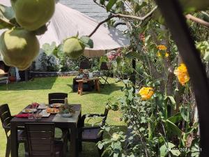 un tavolo e sedie in un giardino fiorito di Casa Baraquel ad Arequipa