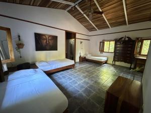 1 dormitorio con 2 camas y mesa. en Star Mountain Jungle Lodge - Mal Pais, Santa Teresa, en Mal País
