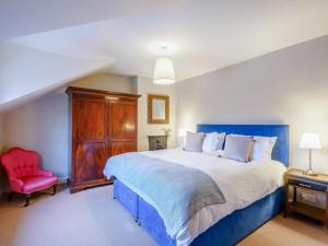 1 dormitorio con 1 cama grande y 1 silla roja en 4 Bed in Harrogate 73424 en Harrogate
