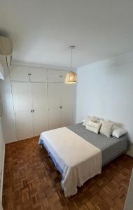 a bedroom with a bed and white cabinets at Dpto Olleros in Buenos Aires
