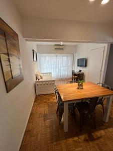 a dining room with a table and a living room at Dpto Olleros in Buenos Aires