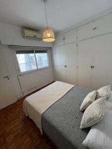 a bedroom with a bed and a pendant light at Dpto Olleros in Buenos Aires