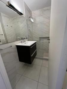 a white bathroom with a sink and a shower at Dpto Olleros in Buenos Aires