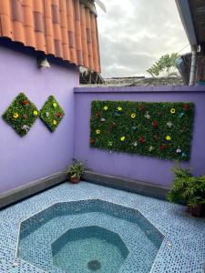 una pared púrpura con un jardín de flores y plantas en La casa de naty by Ecuapolsky, en Tonsupa