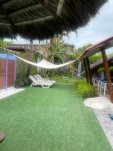 a patio with a hammock and chairs on it at La casa de naty by Ecuapolsky in Tonsupa