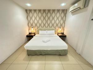 a bedroom with a white bed with two lamps at Alia Express Hotel Twelve a12 Kuantan in Kuantan