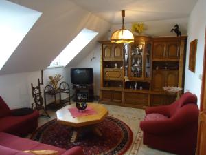 ein Wohnzimmer mit roten Stühlen, einem Tisch und einem TV in der Unterkunft Apartment Duhová in Franzensbad
