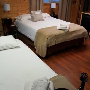 2 letti in una camera d'albergo con pavimenti in legno di Halibut House a Seward