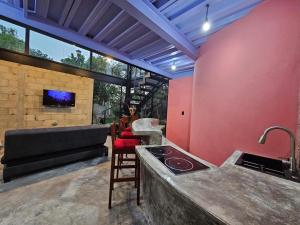 a kitchen with a stove and a couch in a room at Saak Luúm Ruta Puuc in Sacalum
