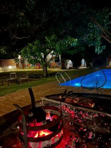 a fire pit in a park next to a pool at BROTHERS HOSTEL in Villa Allende