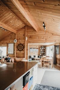 a woman sitting on a couch in a living room at Tatahi Cove Back Packer in Hahei