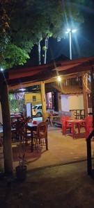 a restaurant with tables and chairs at night at Ali Atrás in Macaé