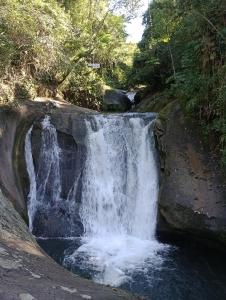a waterfall on the side of a river at Ali Atrás in Macaé