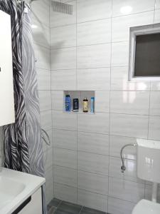 uma casa de banho com uma cortina de chuveiro e um lavatório em Apartman Mira&Ahmet em Stolac