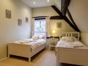 a bedroom with two beds and a window at 2 Bed in Evesham 49245 in Cleeve Prior