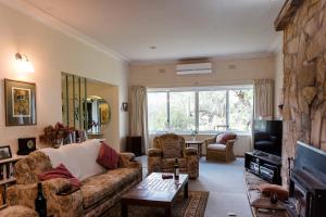 a living room with a couch and a tv at Corowa Oakleigh Hideaway in Hopefield