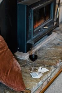 a glass of red wine next to a fireplace at Corowa Oakleigh Hideaway in Hopefield