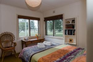 a bedroom with a bed and a chair and windows at Corowa Oakleigh Hideaway in Hopefield +31 photos
