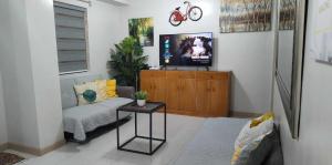 a living room with a couch and a tv at 1608 Three Bedrooms With 1 free parking, swimming pool WiFi and Netflix at Northpoint Camella Condominium Bajada Davao City in Davao City