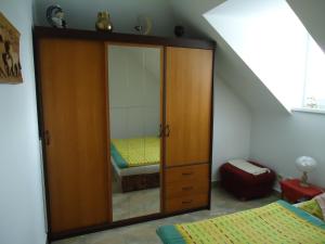 ein Schlafzimmer mit einem großen Holzschrank und einem Spiegel in der Unterkunft Apartment Duhová in Franzensbad