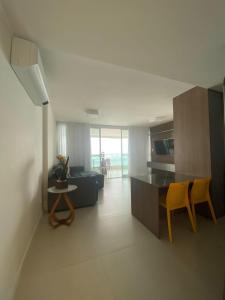 cocina y sala de estar con sofá y mesa en Apartamento na Barra alto padrão com vista mar, en Salvador