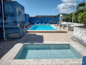 een zwembad op een binnenplaats met een blauwe muur bij Casa Temporada Prainha - Aquiraz in Aquiraz