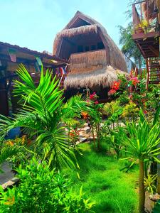 Maison atropique avec un toit en gazon et des plantes dans l'établissement Good Vibes Bungalows, à Gili Trawangan