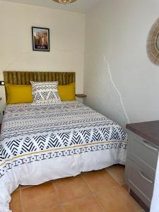 1 dormitorio con 1 cama con edredón blanco y negro en Centre de Collioure Appartement tout confort 2-4 pers avec climatisation et wifi classé 2 étoiles, en Collioure