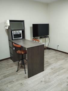 a desk with a computer and a television in a room at Flat charmoso na praia de Juquehy in São Sebastião