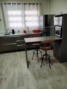 una cocina con mesa y 2 sillas. en Flat charmoso na praia de Juquehy, en São Sebastião