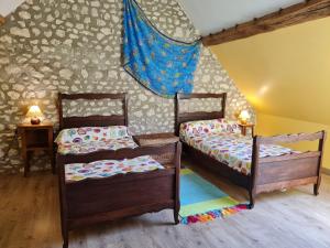 two twin beds in a room with a wall at Gîte en campagne proche Orléans et Blois avec jardin paysager, pour 6 pers., calme assuré - FR-1-590-109 in Saint-Ay