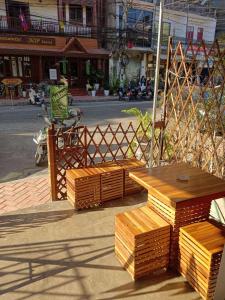 una mesa de madera y bancos al lado de una calle en Annie Backpacker Hostel, en Ban Nongdouang