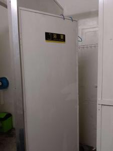 Una puerta blanca con un cartel en una habitación en Annie Backpacker Hostel, en Ban Nongdouang