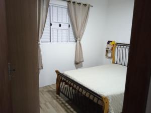 Habitación pequeña con cama y ventana en Casa no Campeche para veraneio com internet, en Florianópolis