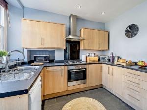 una cocina con armarios de madera y un reloj en la pared en 3 Bed in Kendal 91839, en Kendal
