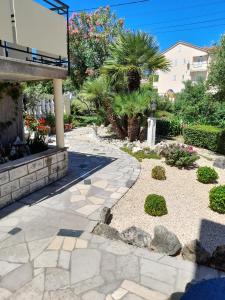 a garden with a stone walkway and plants at Apartments and rooms with parking space Palit, Rab - 22221 in Rab +28 photos