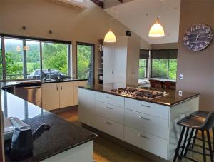 uma cozinha com armários brancos e uma bancada em Arcadia Views em Witta