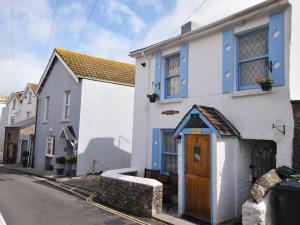 una casa blanca con acentos azules en una calle en 1 bed in Brixham 73940, en Brixham