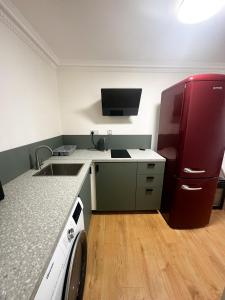 a small kitchen with a sink and a refrigerator at Flat 1 Stay In Aldgate in London