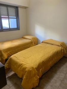 - 2 lits avec des couvertures jaunes dans une pièce dans l'établissement Departamento -Ambrosio- a 100mts de Plaza España, Pleno Nueva Cordoba, para 4 personas, By Apartcba, à Córdoba