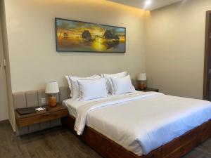 ein Schlafzimmer mit einem Bett und einem Wandgemälde in der Unterkunft Mr. Boss House Apartment in Đà Nẵng