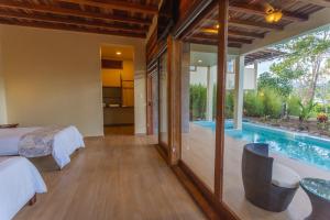 a bedroom with a bed and a swimming pool at El Jardin Lodge & Spa in Puerto Misahuallí